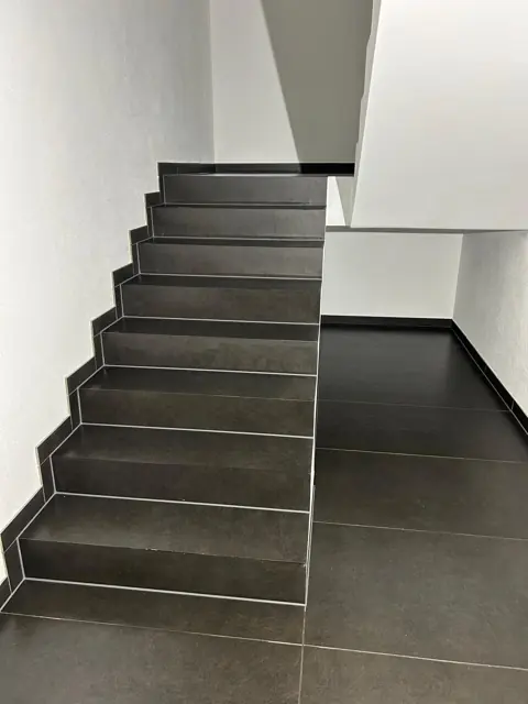 Treppe mit anthrazitfarbenen Trittstufen und Setzstufen